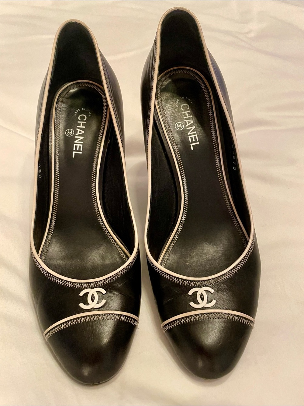 CHANEL Black Leather Pumps with White Trim and CC Emblem